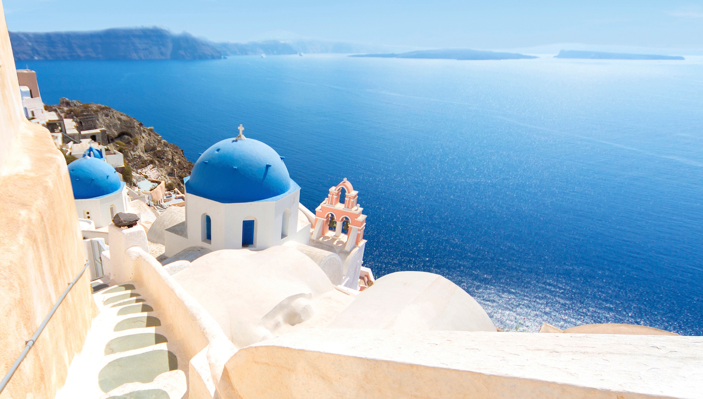 Iconic blue-domed churches overlooking the Aegean Sea in Santorini \| MSC Cruises