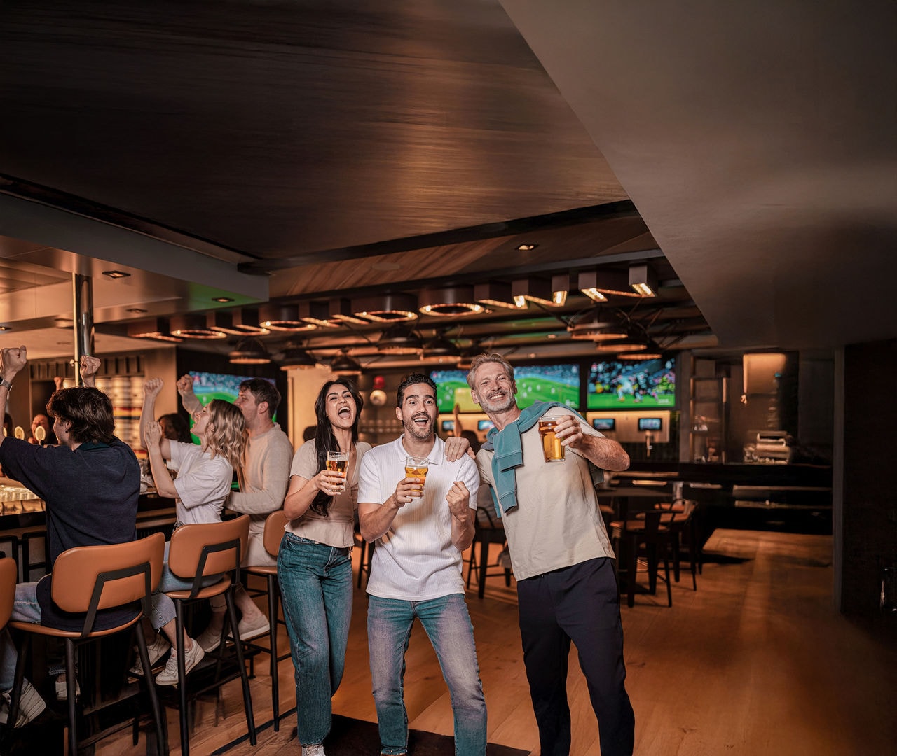 Guests enjoy drinks in a lively sports bar with contemporary décor | MSC Cruises