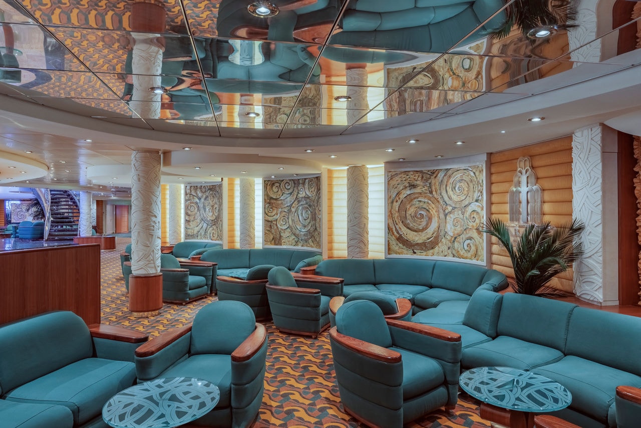 Spacious cruise ship lounge with cozy sofas and tables for relaxing moments | MSC Cruises