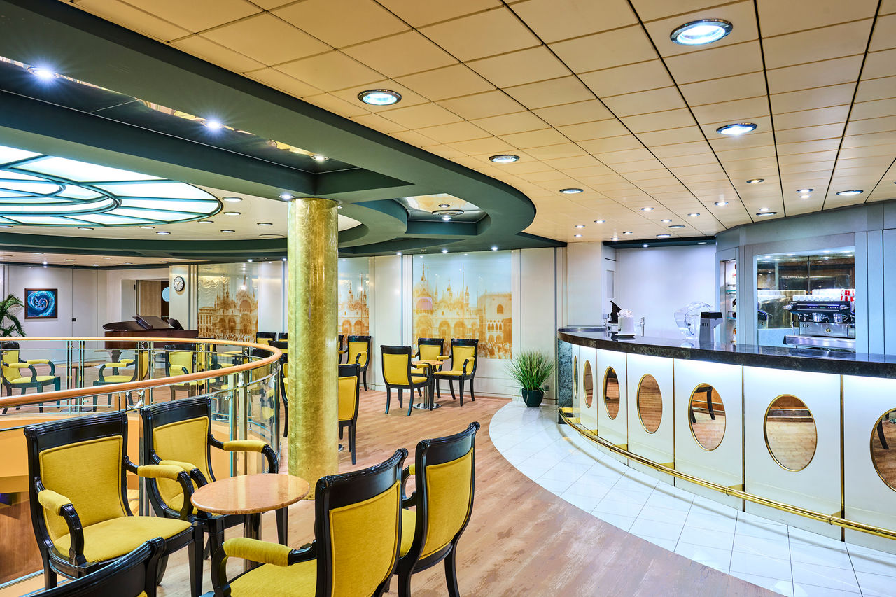 Modern café on MSC Armonia features comfortable seating, a bar, and a piano for guests | MSC Cruises