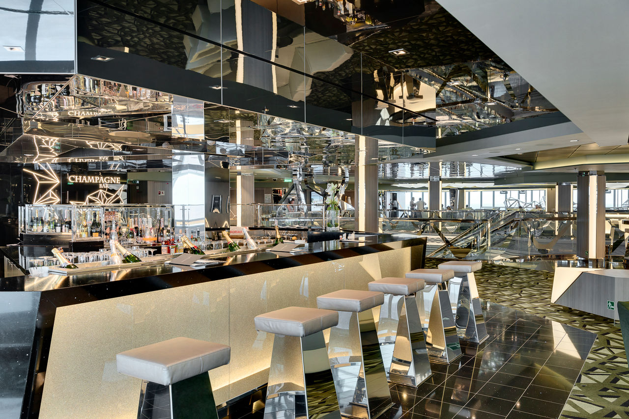 Champagne bar with sleek stools and a luminous bar counter aboard the ship | MSC Cruises