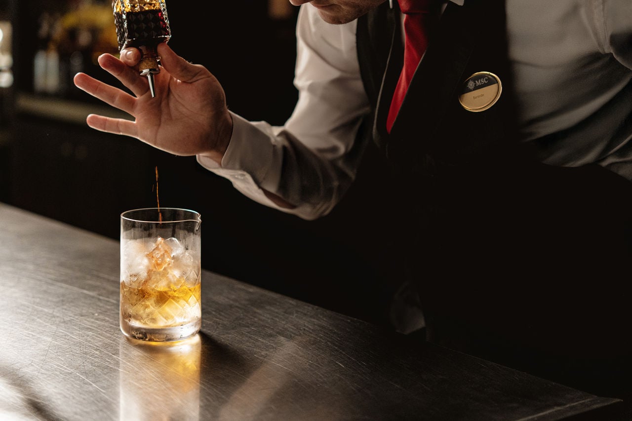 Bartender crafting a cocktail at a stylish specialty bar counter | MSC Cruises
