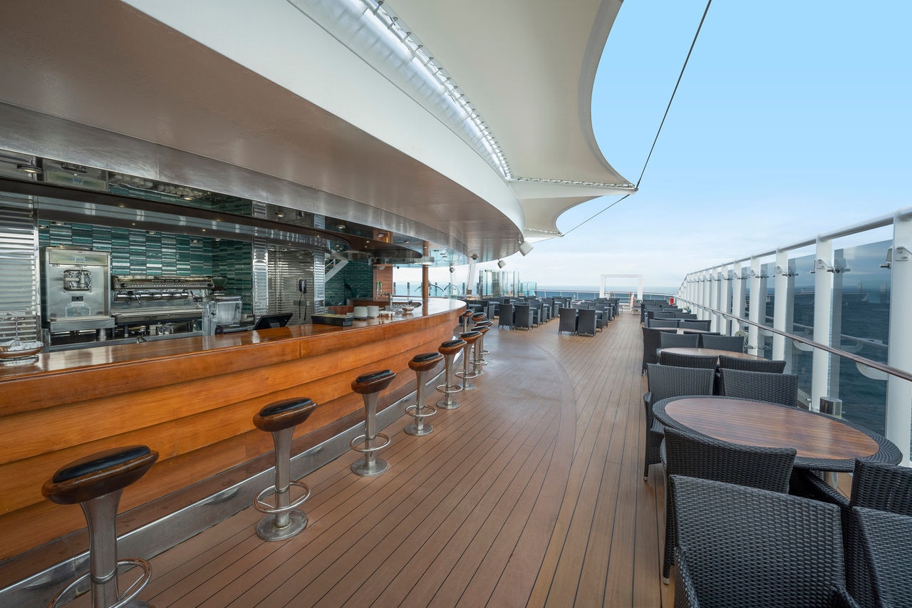 The Garden Bar features wooden chairs and tables with views of the sea and sky | MSC Cruises