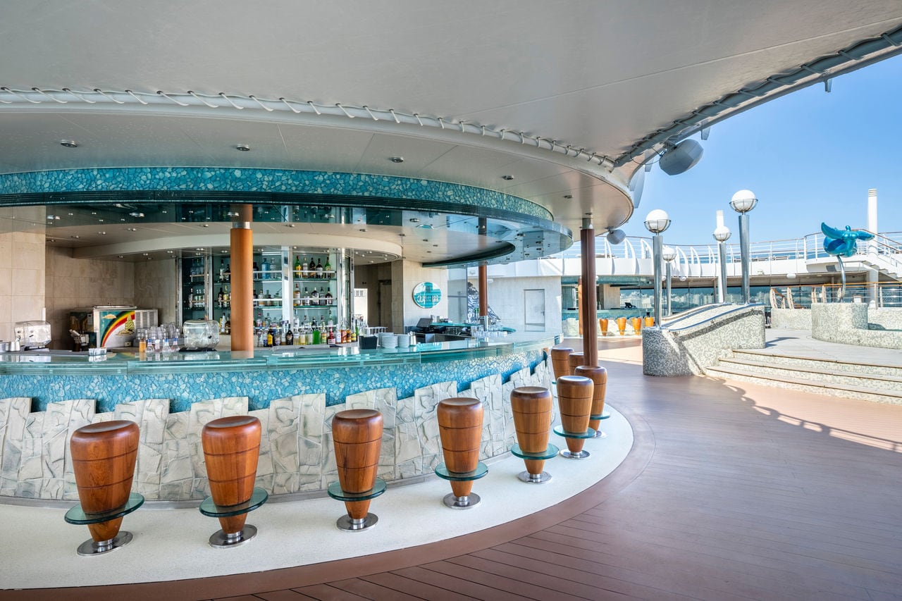 Bar with tall stools and pool view on MSC Fantasia ship | MSC Cruises