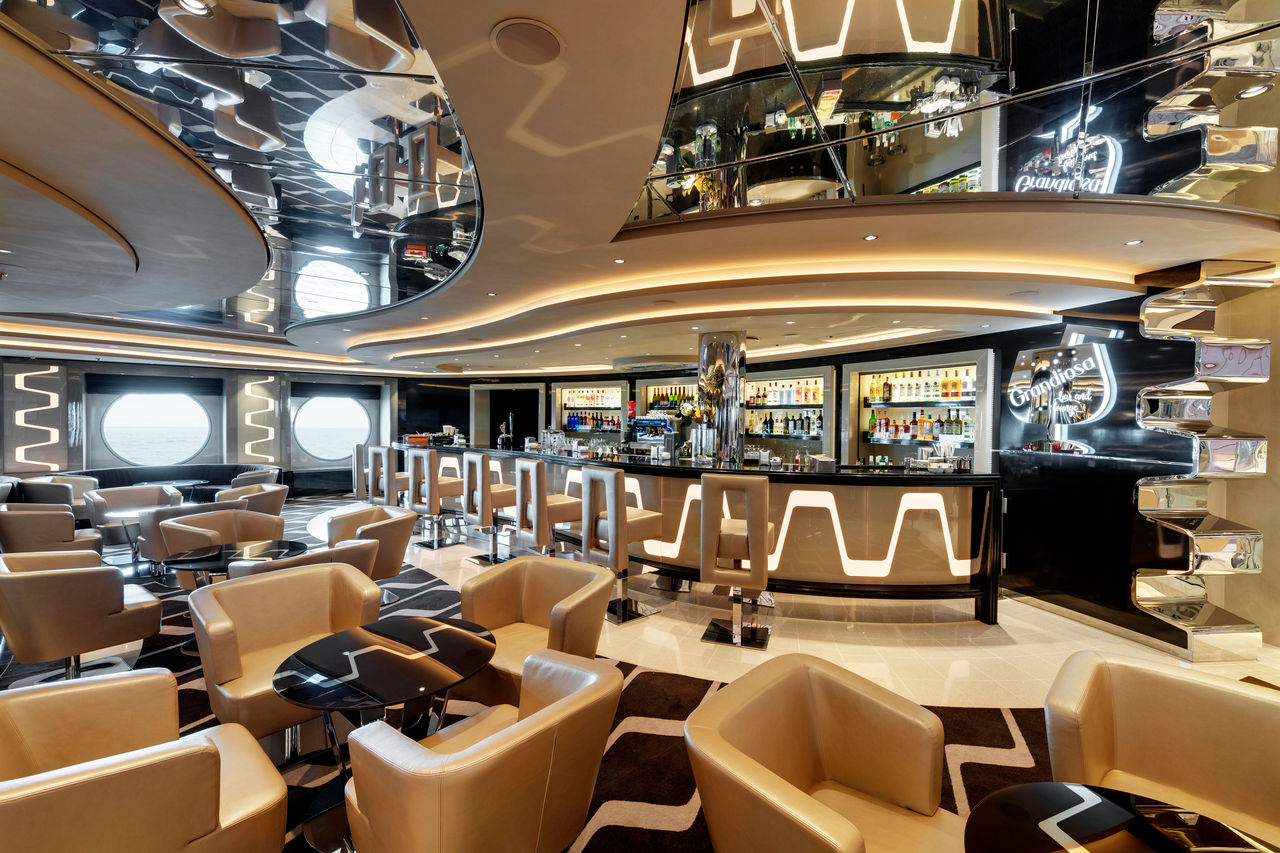 Spacious bar and lounge with comfortable seating and bar counter aboard MSC Grandiosa | MSC Cruises