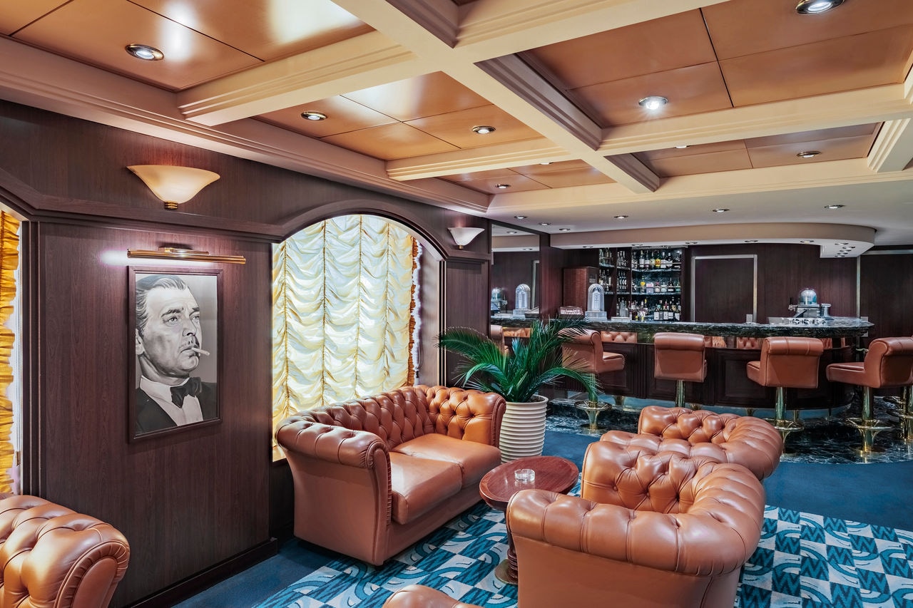 Havana Club lounge with leather armchairs, bar counter and plant aboard MSC Musica | MSC Cruises