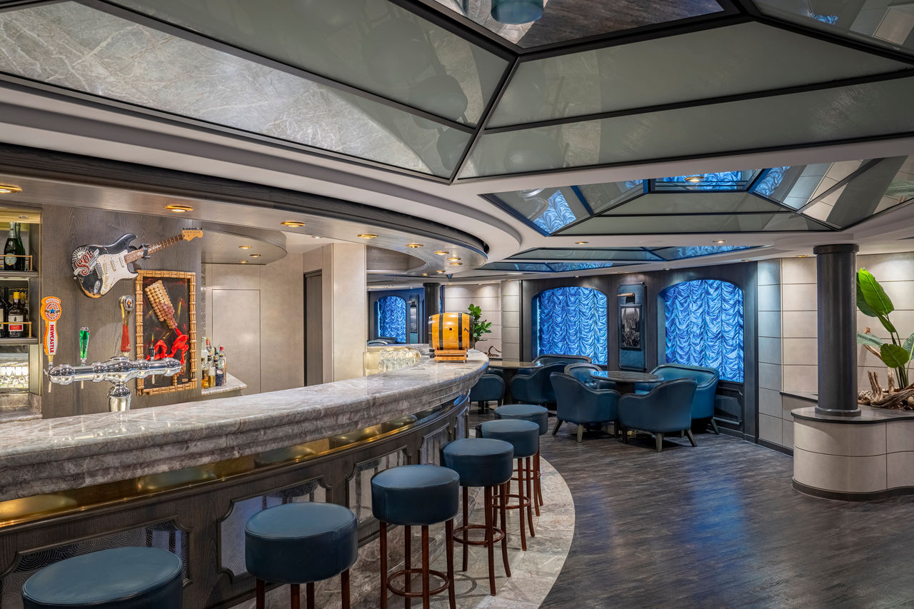 Bar with stylish seating and large windows aboard MSC Poesia inviting relaxation | MSC Cruises