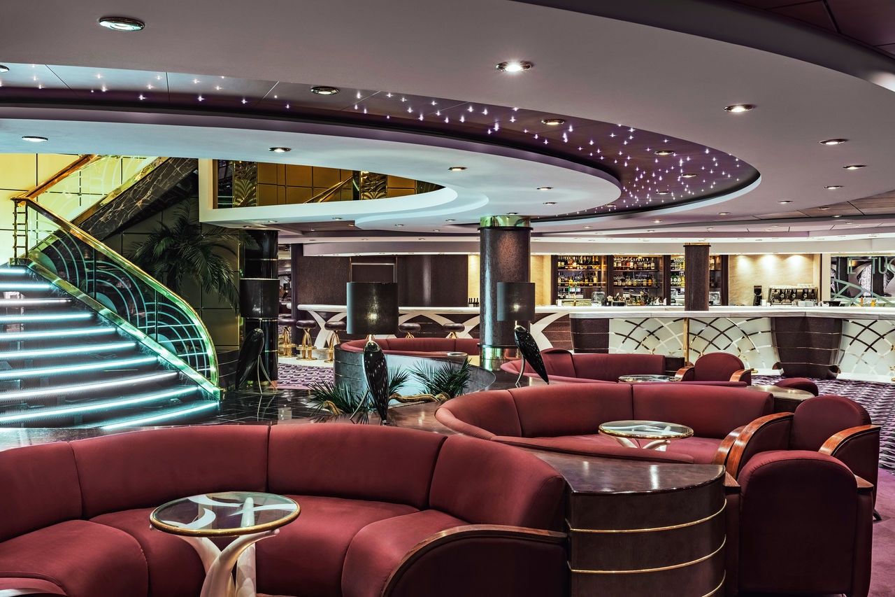 Spacious lounge with comfortable sofas and tables for relaxing in welcoming surroundings | MSC Cruises