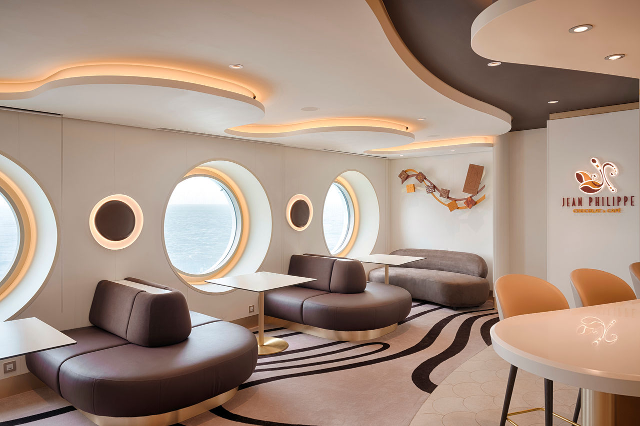 Inviting seating area with porthole windows at Jean-Philippe Chocolat & Café on MSC World America | MSC Cruises