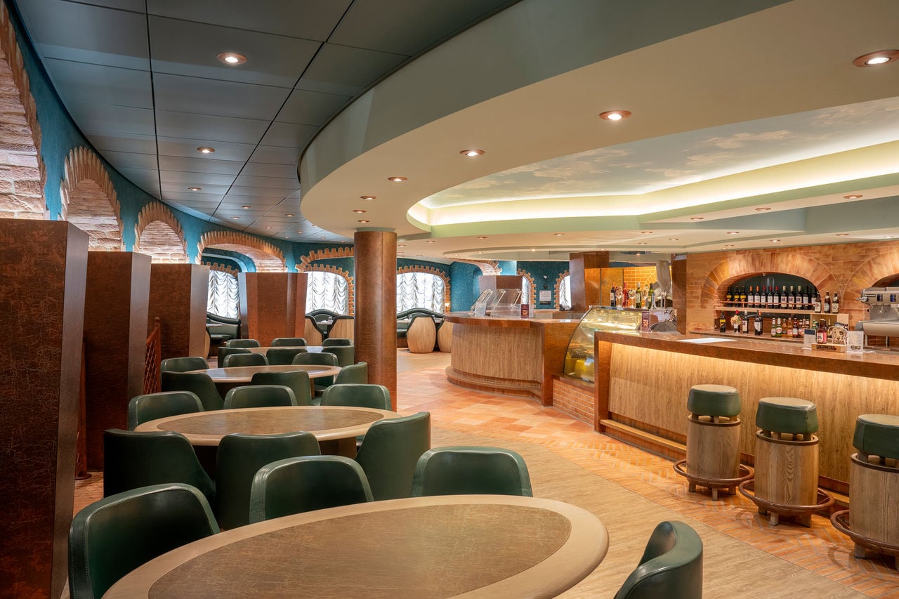 Inviting seating area with armchairs and tables in the lounge bar aboard MSC Divina | MSC Cruises