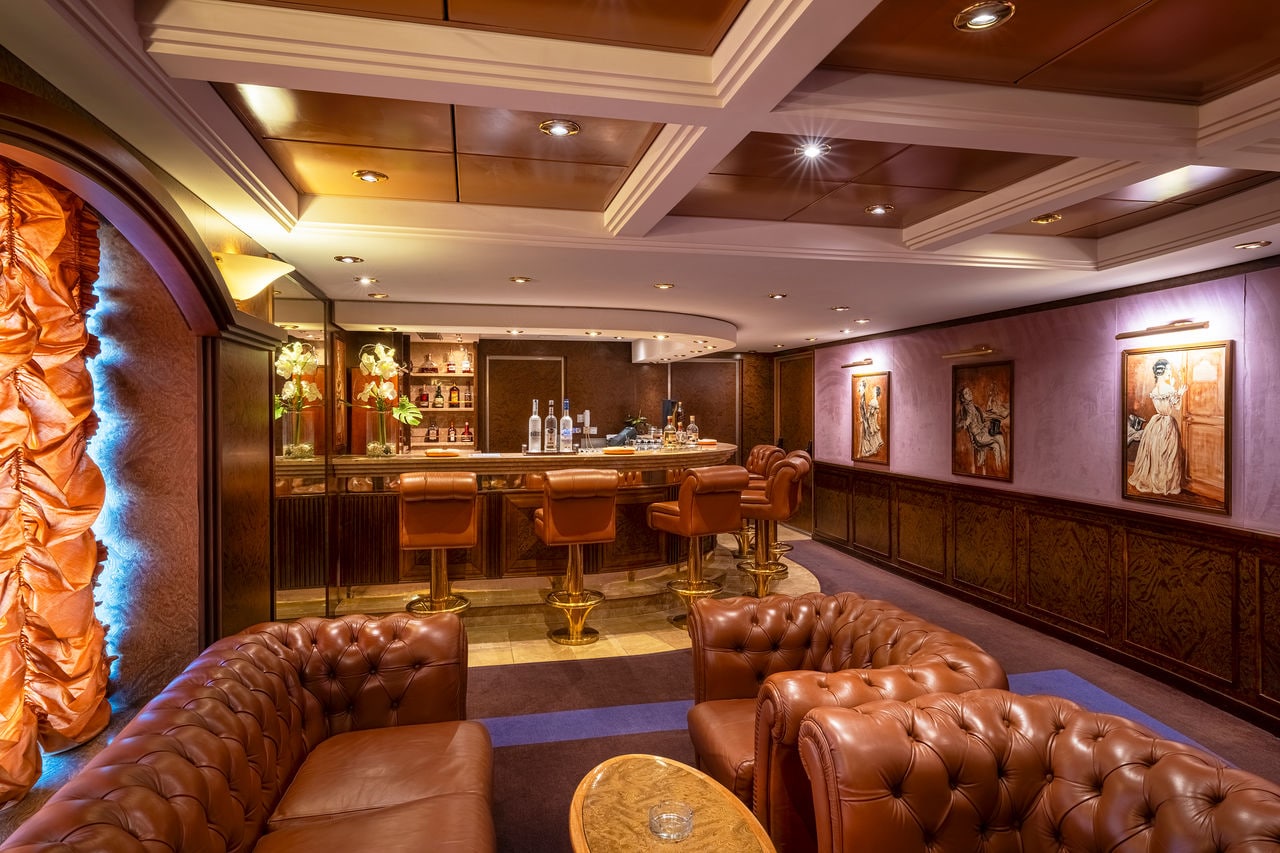 Inviting sitting area with bar and leather sofas in La Cubana lounge aboard MSC Orchestra | MSC Cruises