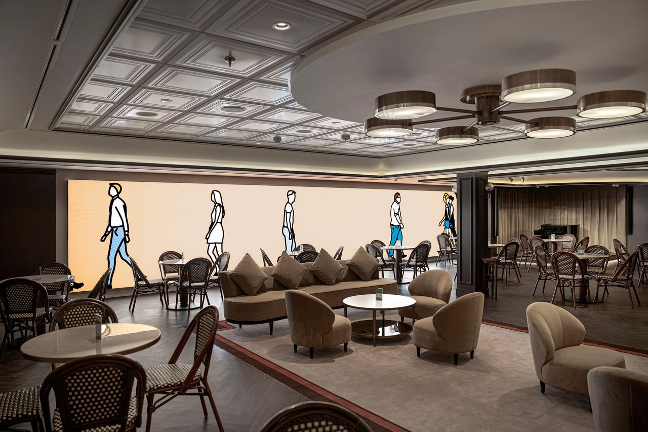 Spacious lounge featuring tables, chairs and piano near large windows | MSC Cruises