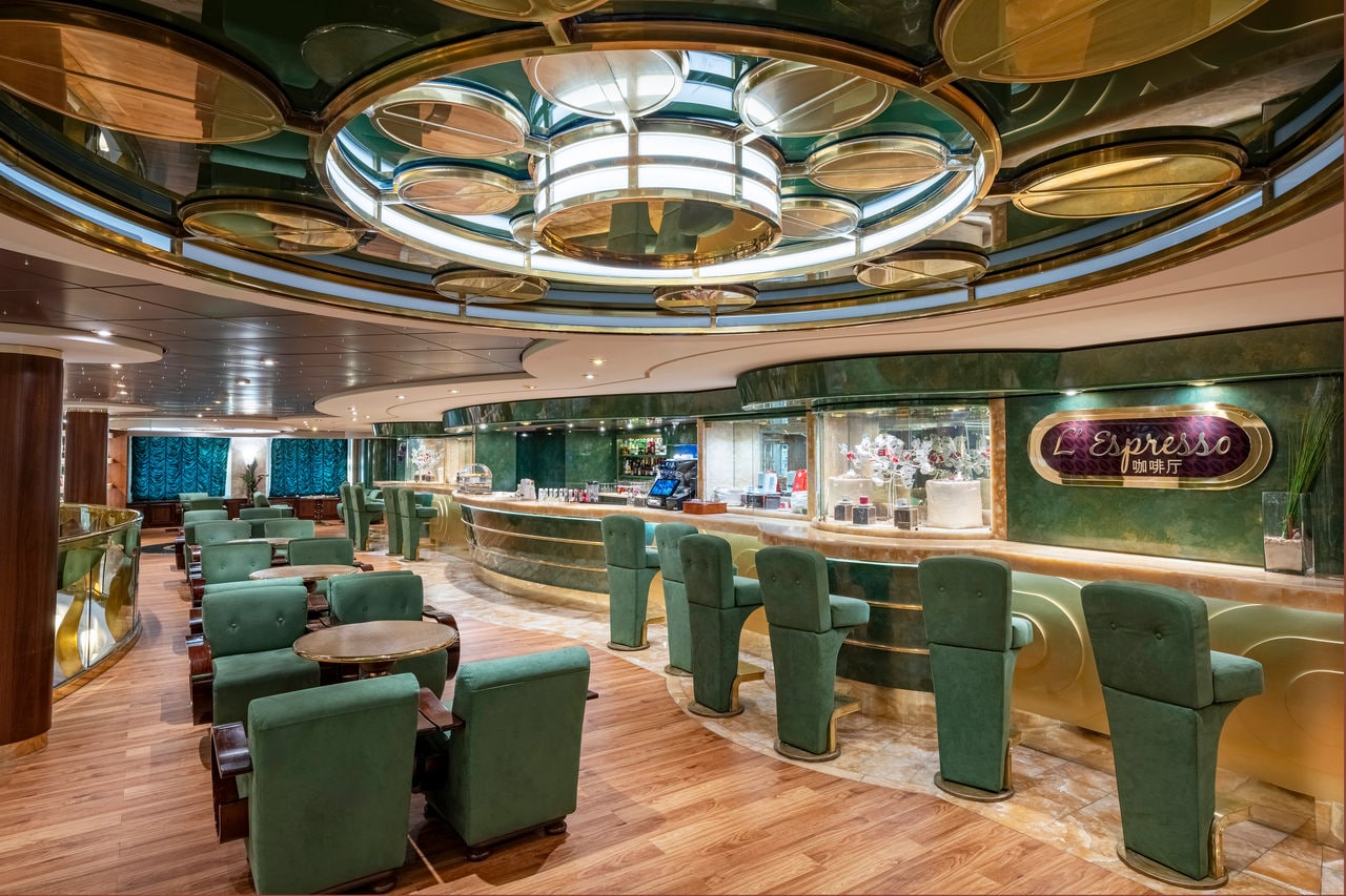 L'Espresso features green seating and a welcoming bar area with warm lighting | MSC Cruises