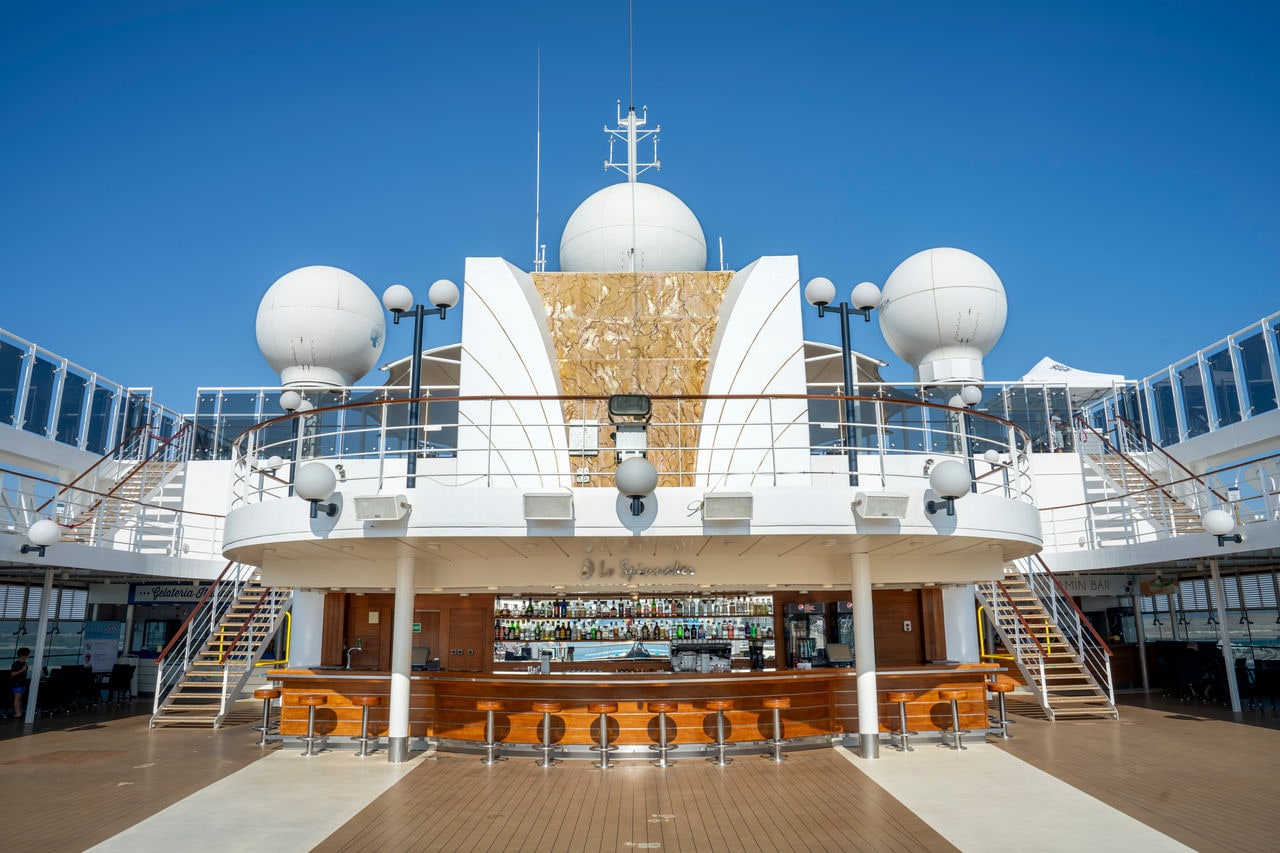 Outdoor bar with wooden counter and elegant modern features on a cruise ship | MSC Cruises