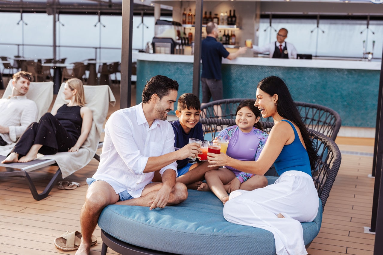 Guests share refreshing drinks together by the pool deck on a cruise ship | MSC Cruises