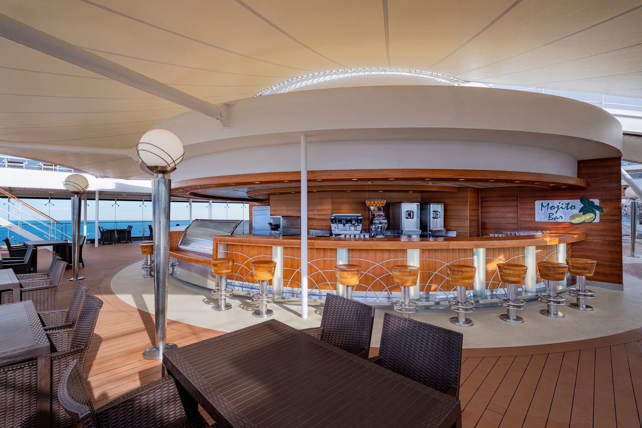 Spacious outdoor bar featuring comfortable seating and panoramic sea views | MSC Cruises