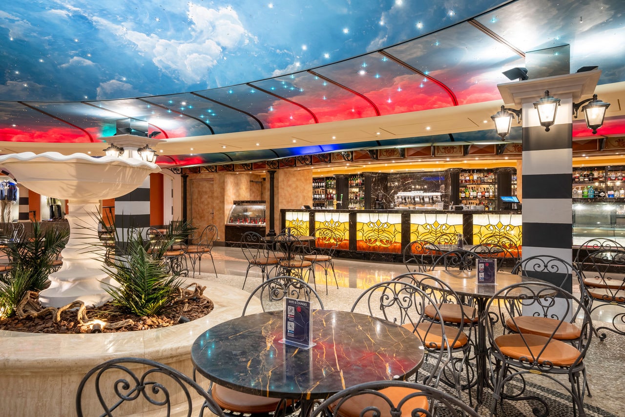 Piazza San Giorgio features a fountain, bar counter, tables and chairs on MSC Fantasia | MSC Cruises