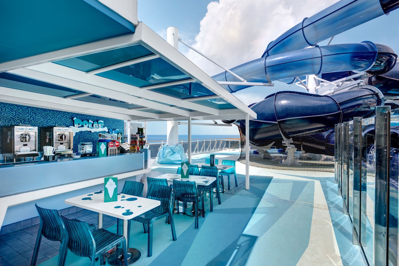 Polar Bar on MSC Meraviglia with tables, poolside seating and a waterslide overlooking the sea | MSC Cruises