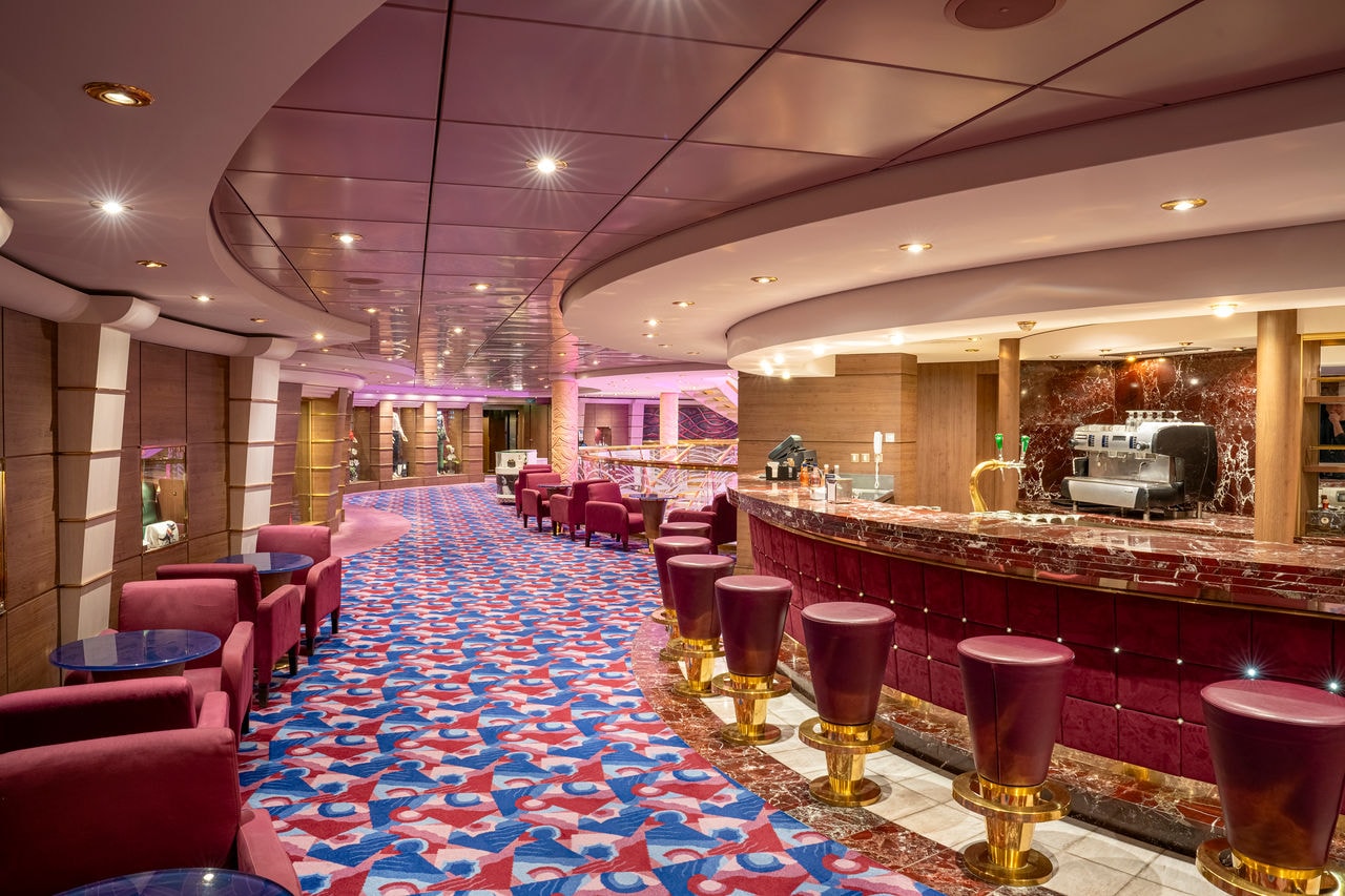 Inviting bar area with plush seating and vibrant carpet on MSC Orchestra | MSC Cruises