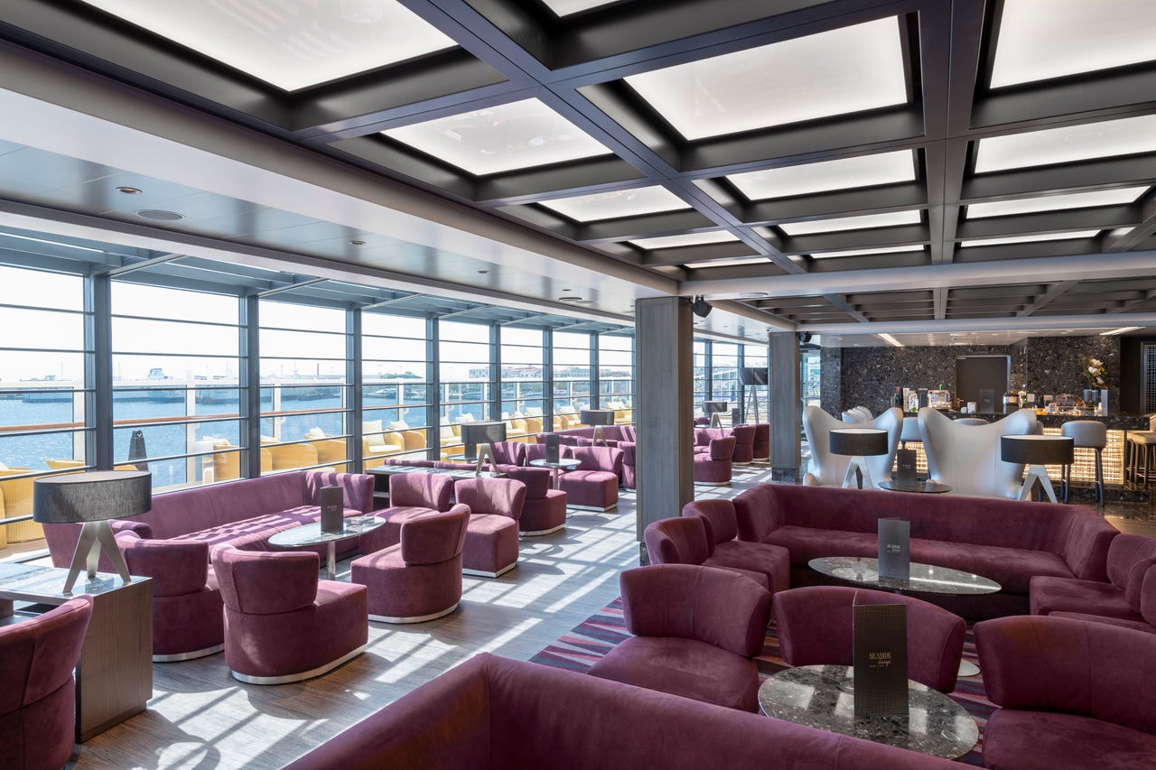 Spacious lounge area with comfortable seating and sea views through large windows | MSC Cruises