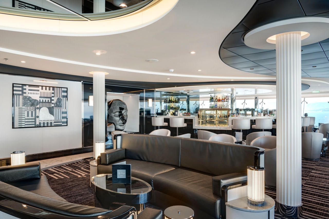Welcoming lounge with sculpture, bar counter and comfortable seating area | MSC Cruises