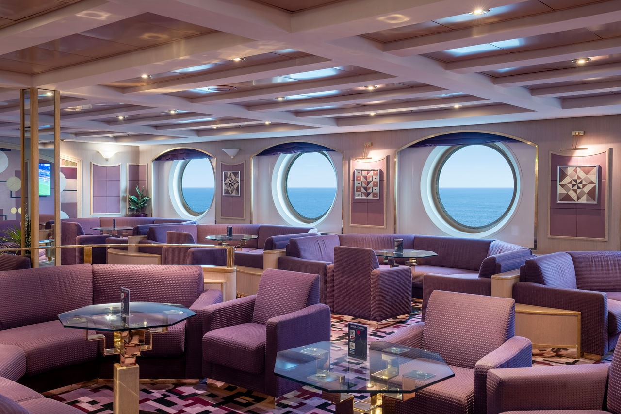 Sitting area with portholes offering sea views in a welcoming lounge | MSC Cruises