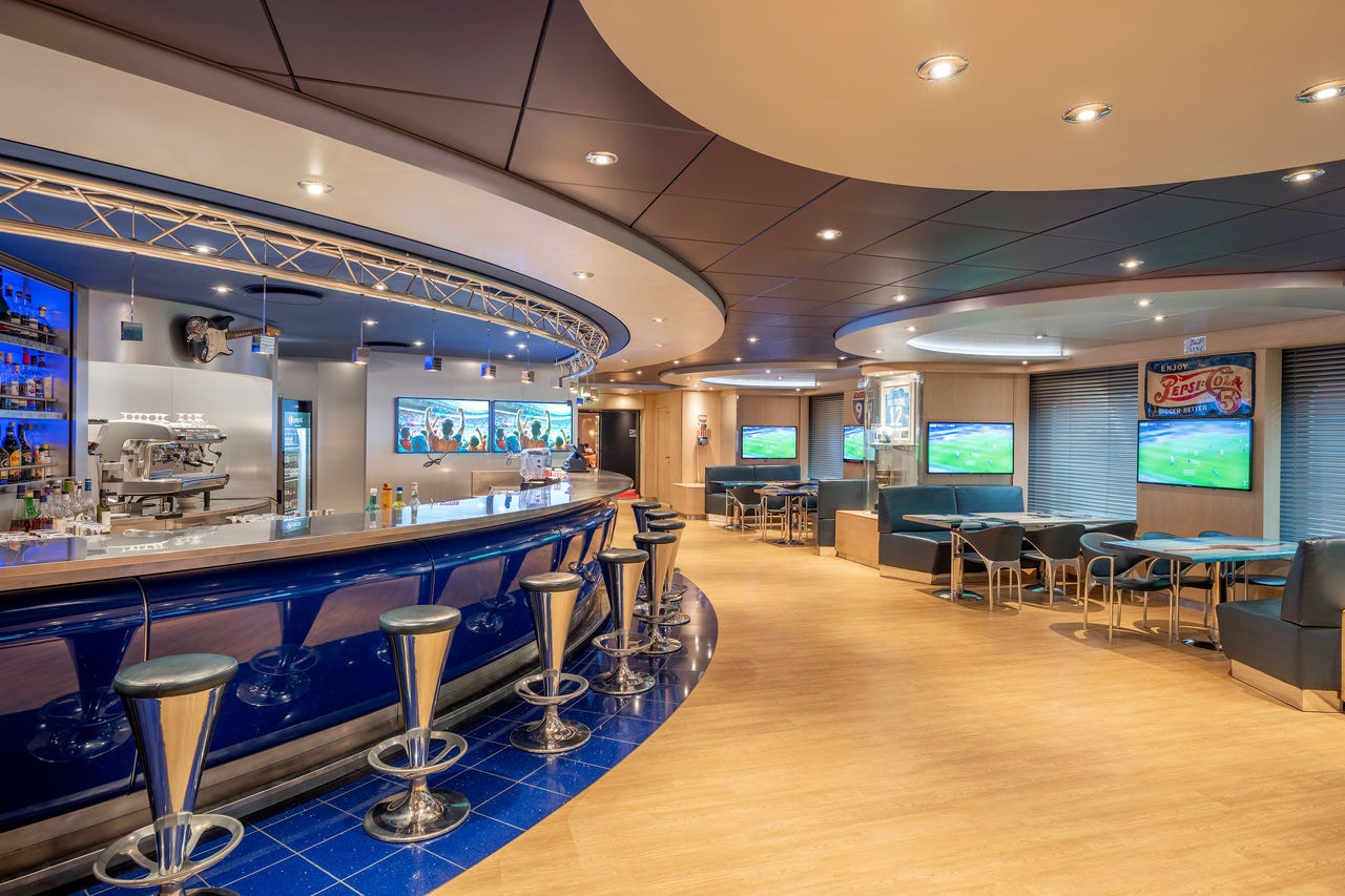 Sports bar with comfortable seating, tables and screens in a lively cruise ship setting | MSC Cruises