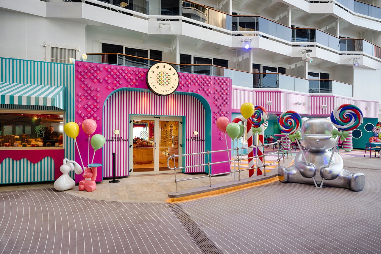 Sweet Temptations entrance with vibrant decorations and seating area aboard MSC World America | MSC Cruises