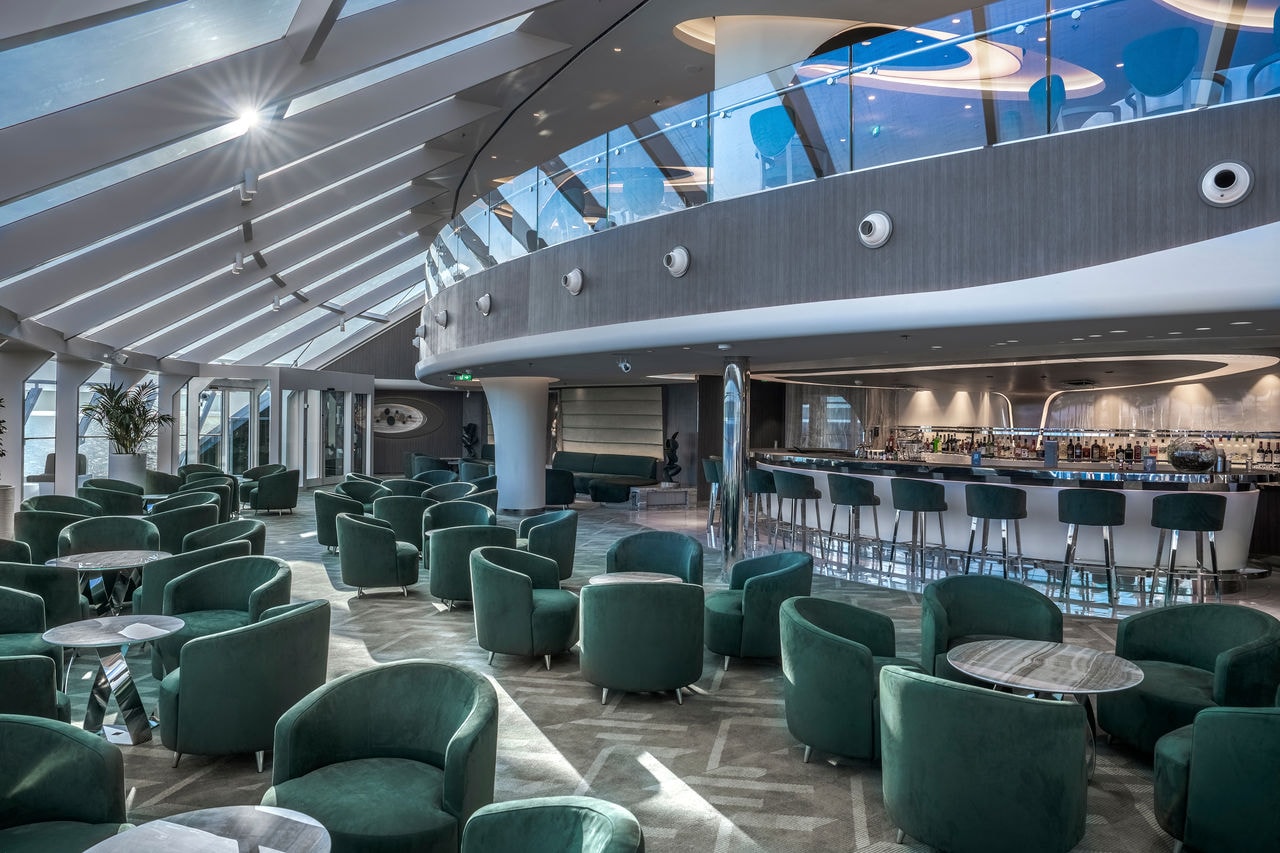 Top Sail Lounge on MSC World Europa features green seating and a stylish bar area | MSC Cruises