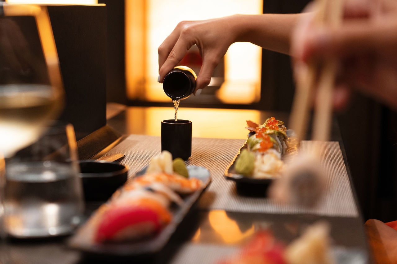 Sushi rolls and sake are served at a stylish table in a welcoming atmosphere | MSC Cruises