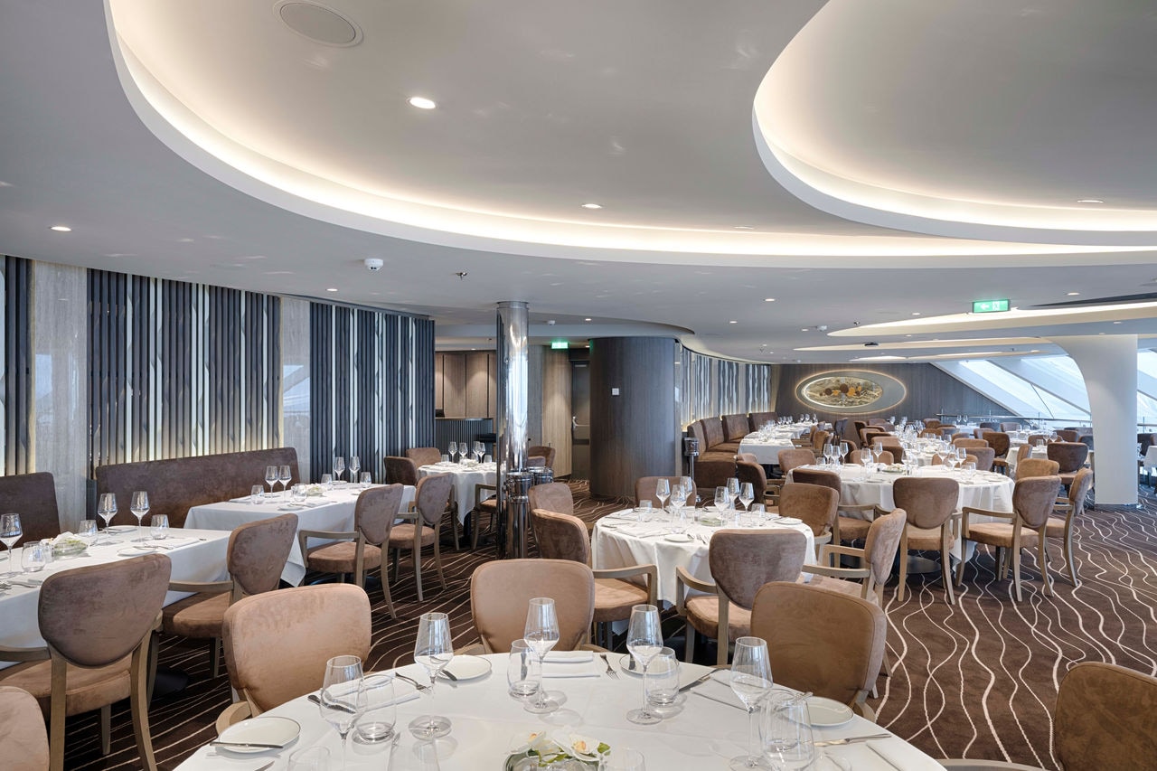 A stylish dining area in the MSC Yacht Club with elegant tables and comfortable chairs for guests to enjoy their meals | MSC Cruises