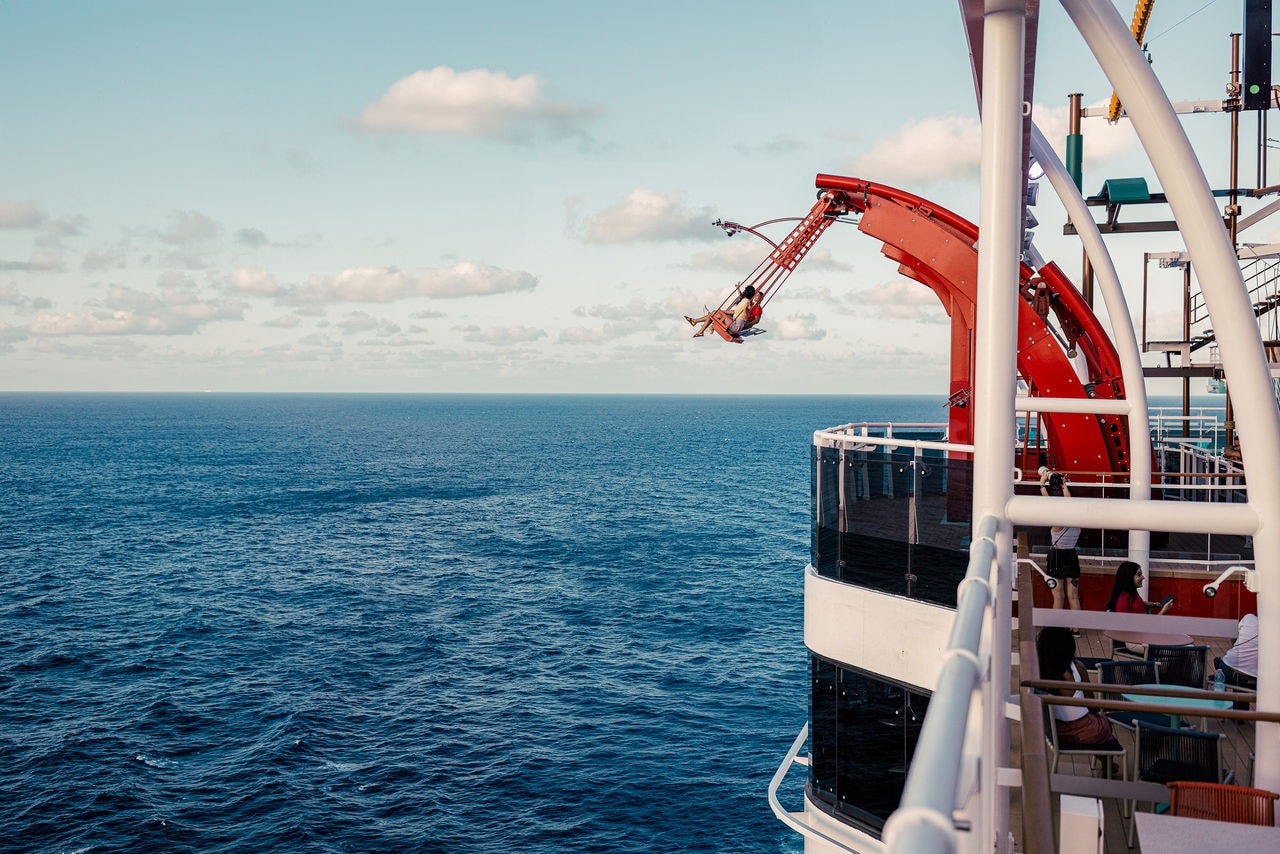 A person slides down a waterslide on a cruise ship overlooking the open blue sea | MSC Cruises