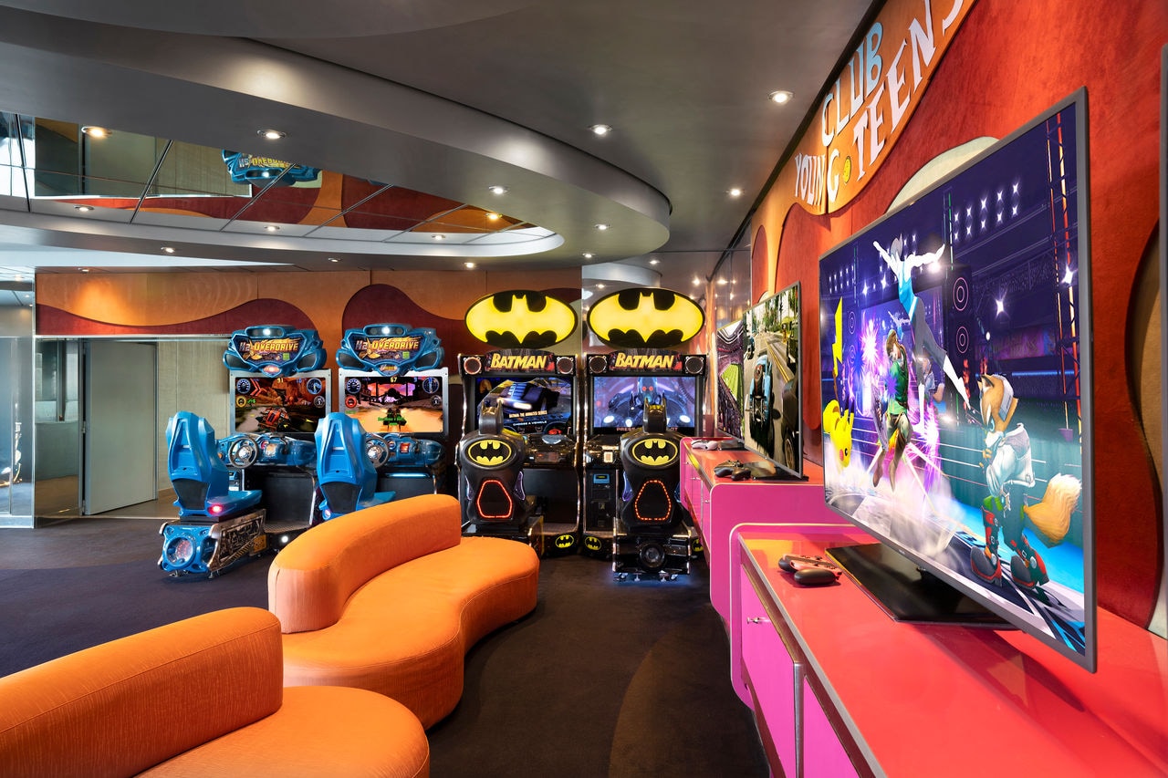 Inspiring entertainment area with vibrant sofas and a large screen for family enjoyment | MSC Cruises