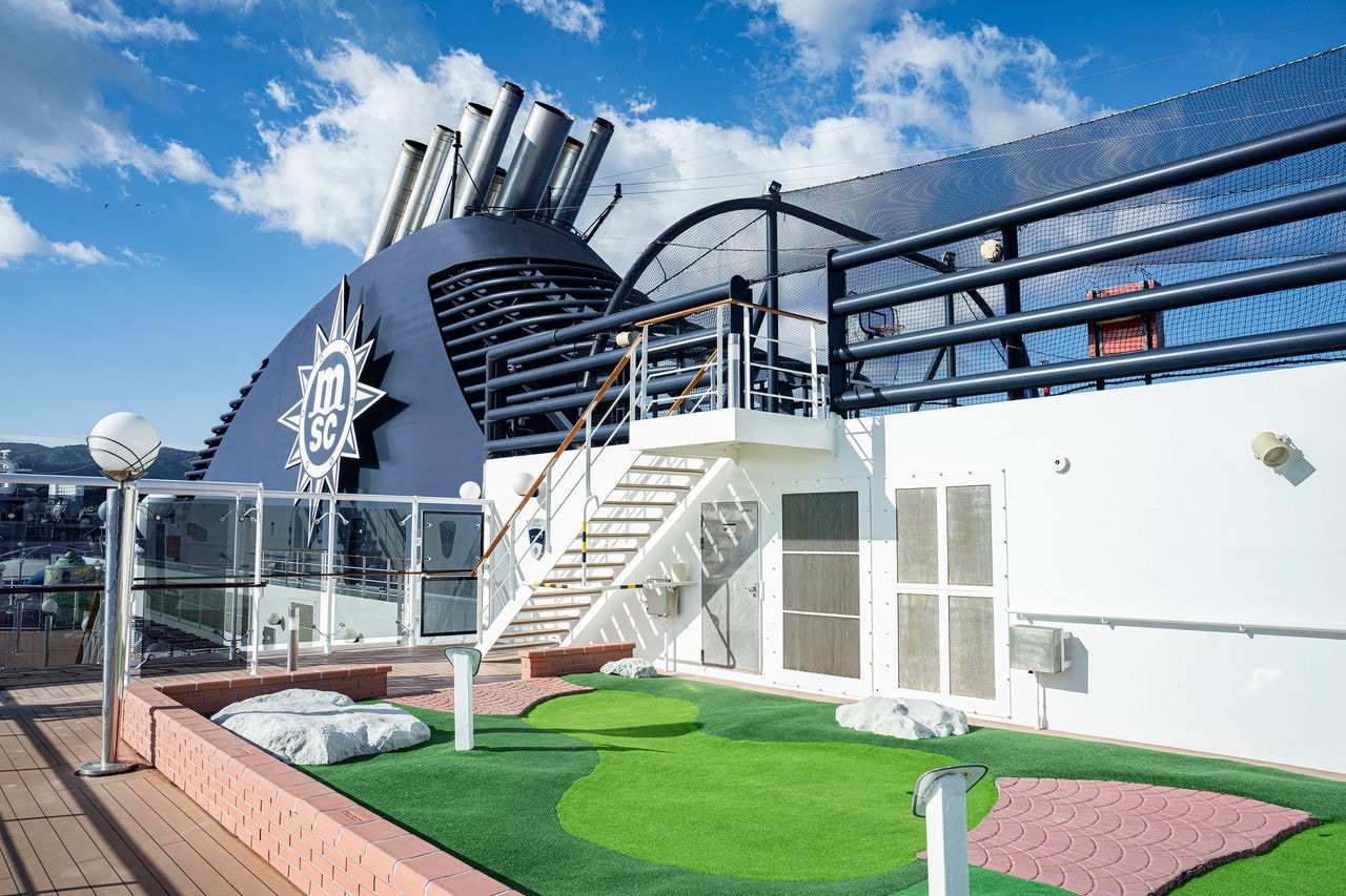 Mini golf course on the deck of a cruise ship surrounded by contemporary amenities | MSC Cruises
