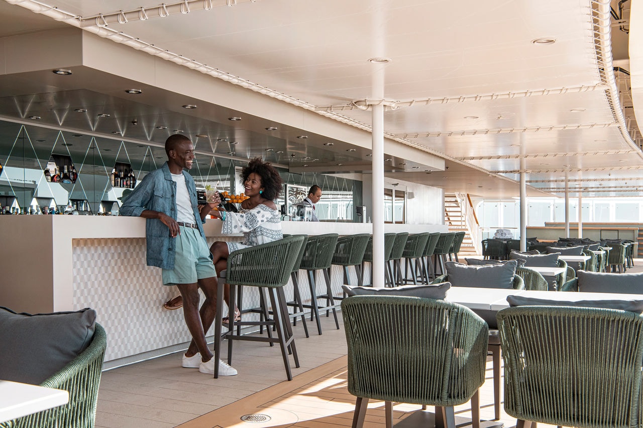 A couple enjoys cocktails at the bar in the exclusive solarium area aboard the cruise ship | MSC Cruises