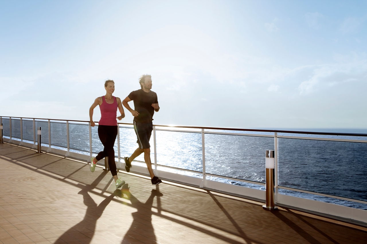 A couple enjoys power walking on the deck’s track with sunrise views over the sea | MSC Cruises