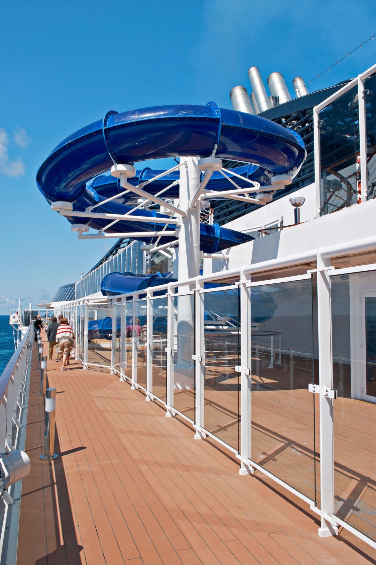 Blue waterslide curves above the outdoor deck of a cruise ship under a clear sky | MSC Cruises